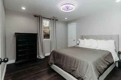 a bedroom with a large bed and a window at Luxury Cliffside Hammock House in Wellington
