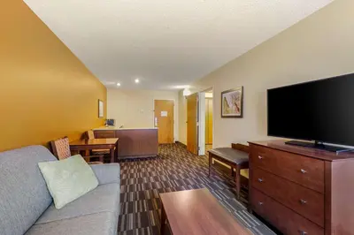 a living room with a couch and a flat screen tv at Best Western Falcon Plaza - Bowling Green in Bowling Green