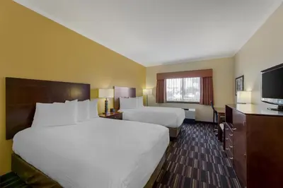 a hotel room with two beds and a flat screen tv at Best Western Falcon Plaza - Bowling Green in Bowling Green