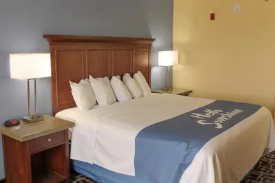 a large bed in a hotel room with two lamps at Days Inn by Wyndham Batavia Ohio in Batavia