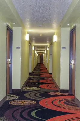 a hallway of a hotel with a long carpeted corridor at Days Inn by Wyndham Batavia Ohio in Batavia
