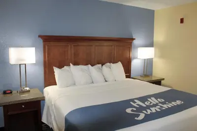a hotel room with a large bed with two lamps at Days Inn by Wyndham Batavia Ohio in Batavia