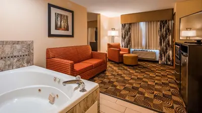 a hotel room with a tub and a living room at Best Western Plus Whitewater Inn in Harrison