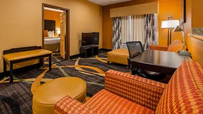 a hotel room with a living area with a piano at Best Western Plus Whitewater Inn in Harrison