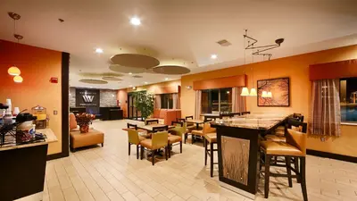 a lobby with a restaurant with tables and chairs at Best Western Plus Whitewater Inn in Harrison