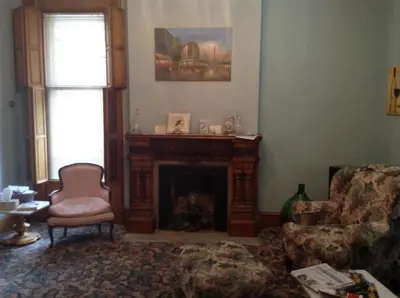a living room with a fireplace and a chair at Inn Port D'Vino in Dayton