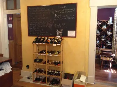a display of wine bottles on a shelf with a chalkboard at Inn Port D'Vino in Dayton
