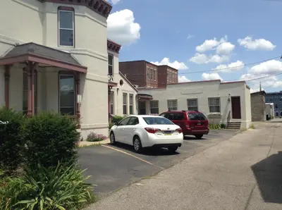 a white car parked in a parking lot next to a house at Inn Port D'Vino in Dayton
