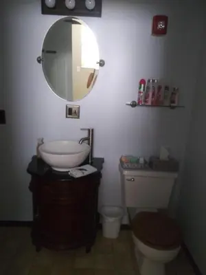 a bathroom with a toilet and a sink and a mirror at Inn Port D'Vino in Dayton