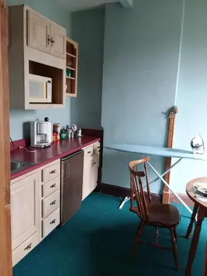 a kitchen with a sink and a chair and a table at Inn Port D'Vino in Dayton