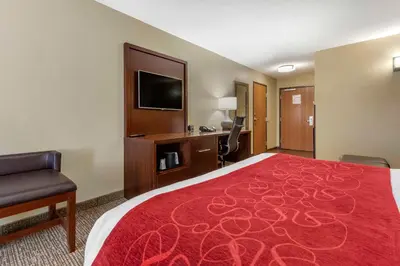 a hotel room with a large bed and a television at Comfort Suites Bridgeport - Clarksburg in Bridgeport