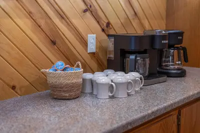 a row of white coffee mugs sitting on a counter at The Lodge at Fields of Home in Millersburg