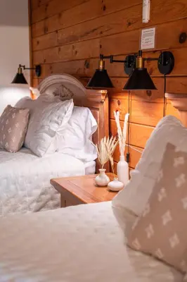 a bedroom with two beds and a wooden wall at The Lodge at Fields of Home in Millersburg