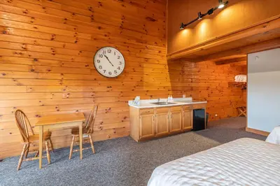 a bedroom with a table and a clock on a wall at The Lodge at Fields of Home in Millersburg