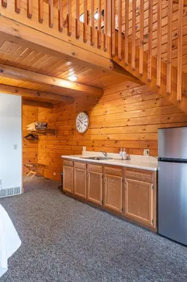 a kitchen with a sink and a refrigerator at The Lodge at Fields of Home in Millersburg