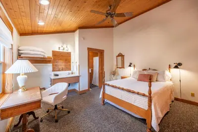 a bedroom with a bed and a desk and a table at The Lodge at Fields of Home in Millersburg