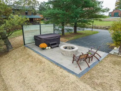 a firepit with two chairs and a grill with a bench at Olive Leaf Cabin in Millersburg