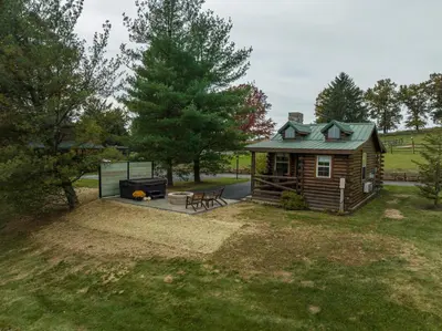 a log cabin with a grill and a picnic table at Olive Leaf Cabin in Millersburg
