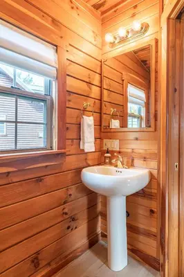 a bathroom with a sink and a window at Olive Leaf Cabin in Millersburg