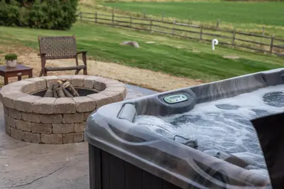 a hot tub with a fire pit in a yard at Olive Leaf Cabin in Millersburg