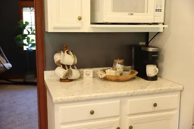 a kitchen counter with white cabinets and a microwave at The Kennedy House in Grayson