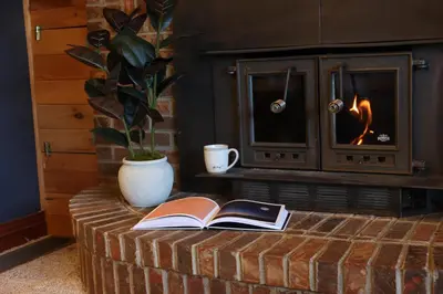 two books on a brick table in front of a fireplace at The Kennedy House in Grayson