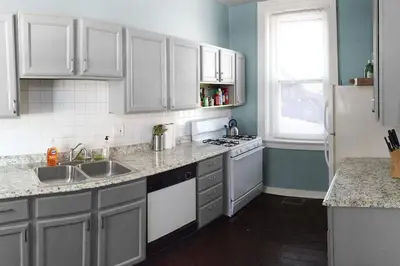 a kitchen with white cabinets and a sink and a window at Cozy Apt in Walkable Area Downtown with Parking in Cincinnati