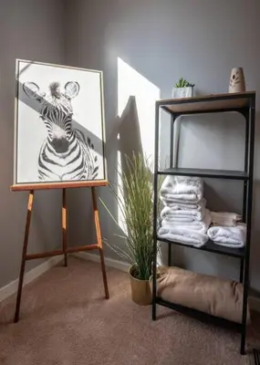 a painting of a zebra on a stand next to a shelf at Cozy Apt in Walkable Area Downtown with Parking in Cincinnati