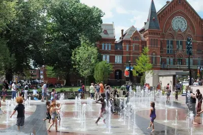 people playing in a fountain in front of a building at Cozy Apt in Walkable Area Downtown with Parking in Cincinnati