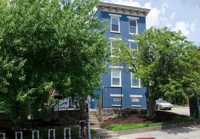 a blue house with trees in front of it at Cozy Apt in Walkable Area Downtown with Parking in Cincinnati