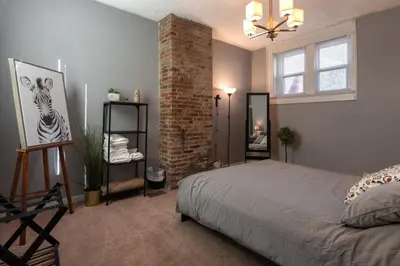 a bedroom with a bed and a brick wall at Cozy Apt in Walkable Area Downtown with Parking in Cincinnati