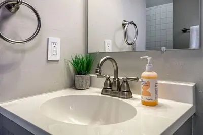 a bathroom sink with a bottle of orange soap on it at 3-BR Soccer Stadium- Fast Drive to OTR - Downtown in Cincinnati
