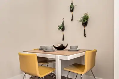 a dining room table with yellow chairs and pineapple decorations at 3-BR Soccer Stadium- Fast Drive to OTR - Downtown in Cincinnati