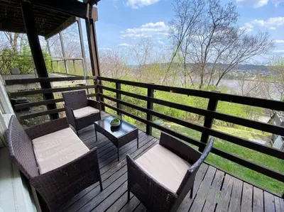 a porch with chairs and a table and a view of a river at Explore Downtown and Mount Adams with River Views in Cincinnati