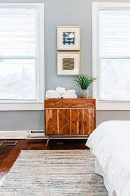 a bedroom with a wooden dresser and two windows at Stylish Flat in Walkable Downtown w Parking in Cincinnati