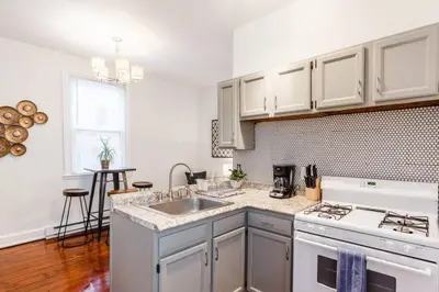 a white kitchen with a sink and a stove at Stylish Flat in Walkable Downtown w Parking in Cincinnati