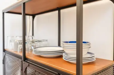 a cabinet with plates and bowls on a shelf at Stylish Flat in Walkable Downtown w Parking in Cincinnati