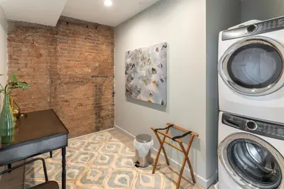 a washer and dryer in a room with a brick wall at Parlor - Explore OTR and DT from Restored 1894 Italianate in Cincinnati