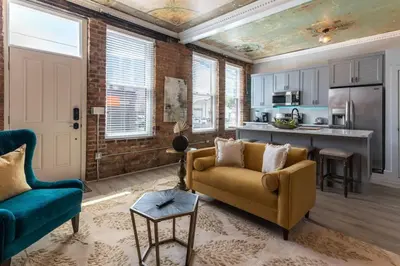 a living room with a couch and a kitchen at Parlor - Explore OTR and DT from Restored 1894 Italianate in Cincinnati