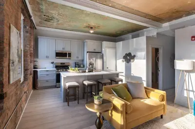 a living room with a couch and a kitchen at Parlor - Explore OTR and DT from Restored 1894 Italianate in Cincinnati
