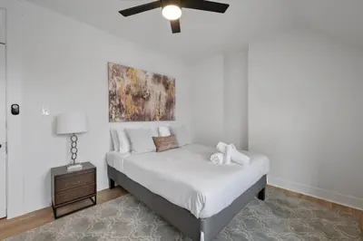 a bedroom with a bed with a ceiling fan at Cozy 2.5BR near Zoo - Hospitals - UC - Free Parking in Cincinnati