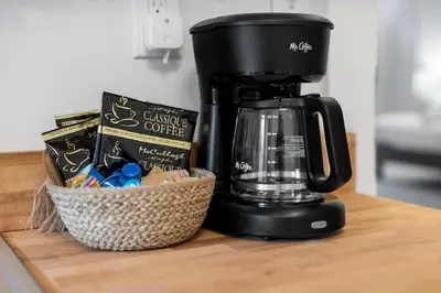 a coffee maker on a counter next to a basket of chips at Cozy 2.5BR near Zoo - Hospitals - UC - Free Parking in Cincinnati