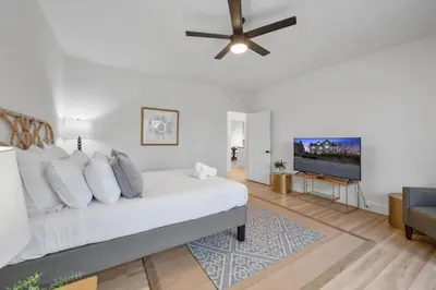 a white bedroom with a bed and a ceiling fan at Cozy 2.5BR near Zoo - Hospitals - UC - Free Parking in Cincinnati