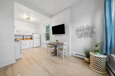 a kitchen and dining room with a table and a tv at Cozy 1BR with Parking - Near UC, Zoo, Downtown in Cincinnati