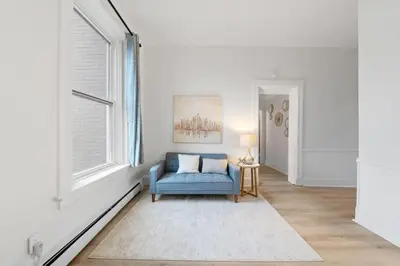 a living room with a blue chair and a window at Cozy 1BR with Parking - Near UC, Zoo, Downtown in Cincinnati
