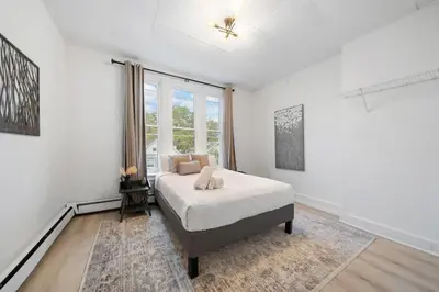 a white bedroom with a bed and a window at Cozy 1BR with Parking - Near UC, Zoo, Downtown in Cincinnati