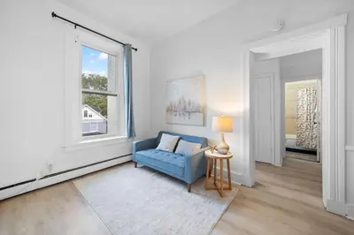 a living room with a blue couch and a window at Cozy 1BR with Parking - Near UC, Zoo, Downtown in Cincinnati