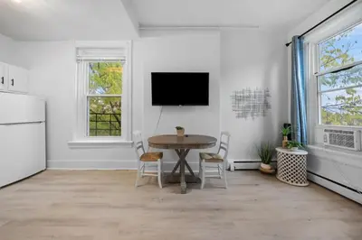 a dining room with a table and a tv on the wall at Cozy 1BR with Parking - Near UC, Zoo, Downtown in Cincinnati