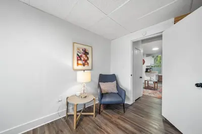 a living room with a chair and a table at Cozy Studio with Parking - Near UC, Zoo, Downtown in Cincinnati