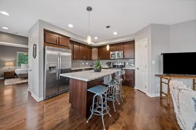 a kitchen with stainless steel appliances and wooden cabinets at Classy 2BR Condo Near City Centre - OTR, UC, Zoo in Cincinnati
